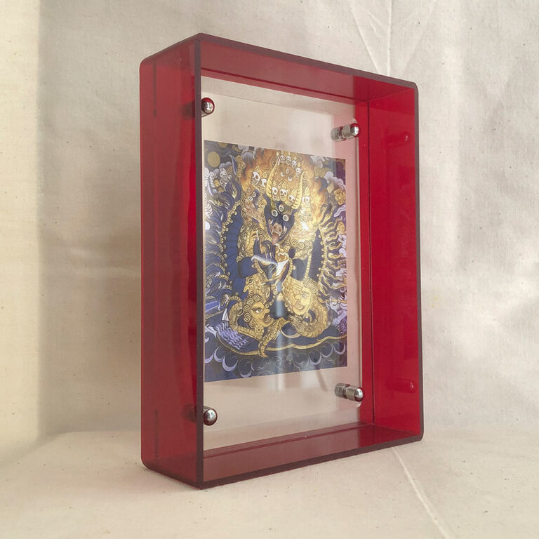 Side view of Yamantaka Thangka art print inside a thick red clear acrylic desk display frame.