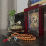 Yamantaka Thangka red acrylic art block styled next to mala beads on a desk.
