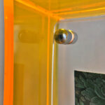 Close-up of magnetic corner screw on amber yellow translucent acrylic display block.