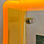 Close-up of magnetic corner screw on amber yellow translucent acrylic display block.