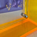 Close-up of magnetic corner screw on amber yellow translucent acrylic display block.