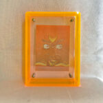 Front view of yellow Jambhala Buddha Eyes print in a yellow floating translucent acrylic frame.