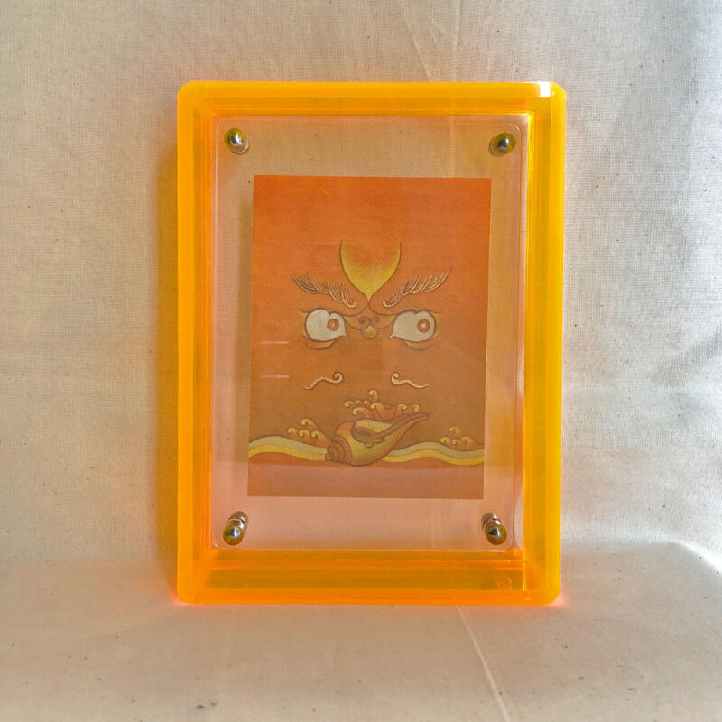 Front view of yellow Jambhala Buddha Eyes print in a yellow floating translucent acrylic frame.