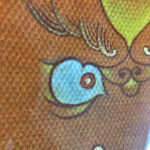 Close-up of original hand-painted gold linework and blue wisdom eyes on yellow canvas texture.