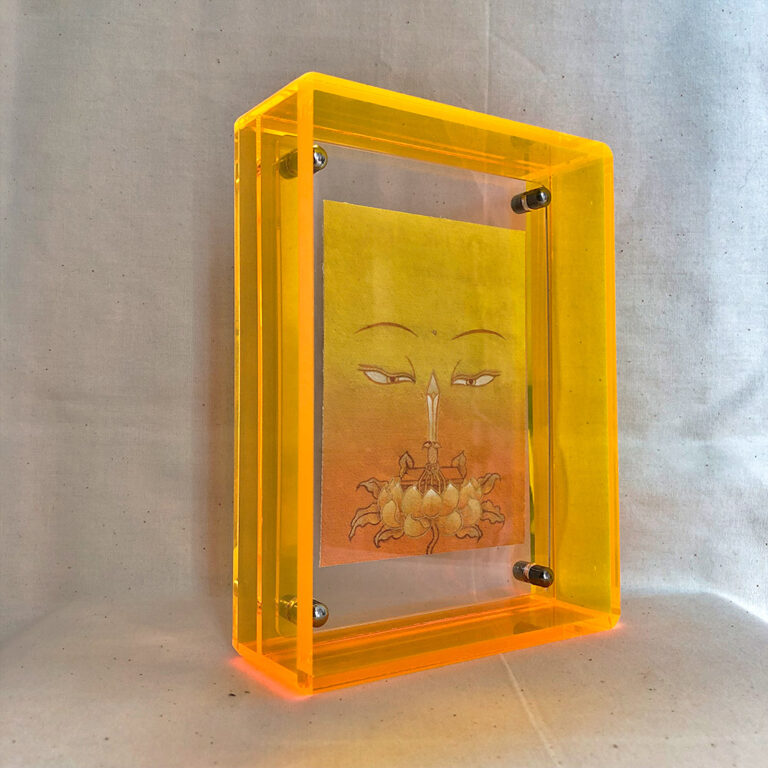 Side perspective of yellow Manjushri Buddha Eyes art inside a yellow translucent acrylic frame.