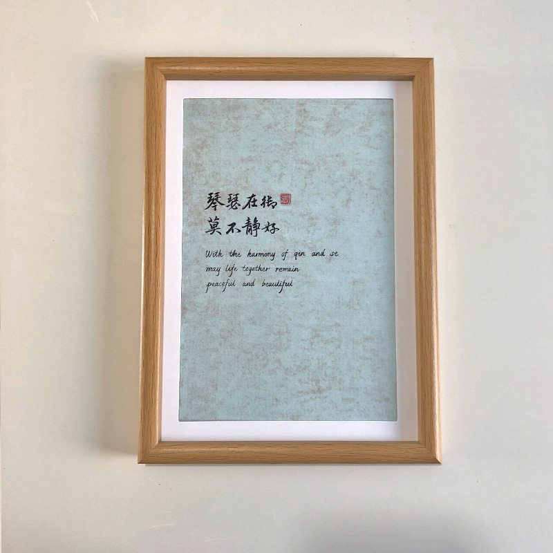 A4 framed light green paper Chinese calligraphy art print for domestic harmony in a natural wood frame