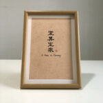 Frontal view of A4 framed Chinese calligraphy art print for home harmony on clean tabletop