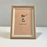 Frontal view of A4 framed Chinese calligraphy art print for kindred spirit on clean tabletop
