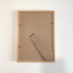 Flat rear view of A4 natural wood picture frame showing craft backing board and metal retaining clips