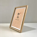 Side perspective view of A4 wooden framed kindred spirit print on tabletop