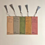 Back panel of five Chinese calligraphy bookmarks displaying handwritten English definitions for health and peace characters.