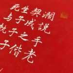 Macro detail of white Xingzhuo Chinese calligraphy characters for love vows and gold seal on red paper