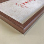 Macro detail of smooth dark walnut wood frame corner for A4 art display
