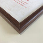 Macro detail of smooth dark walnut wood frame corner for A4 art display