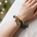 Green Tara Buddha Eye circular pendant bracelet on wrist with green woven thread.