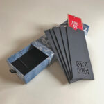 Handwritten 5-piece Chinese calligraphy bookmark set with blue patterned gift box and black protective sleeves.