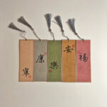 Set of 5 handwritten Chinese calligraphy bookmarks representing Peace, Health, Joy, Tranquility, and Good Fortune with tassels.