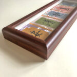 Close-up angled view of rich solid wood frame with handwritten Chinese ink calligraphy.
