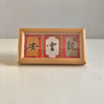 Frontal desktop view of horizontal 3-panel Song Brocade Chinese calligraphy frame for Guan Yun An