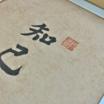 Close-up of Xingzhuo Chinese calligraphy for kindred spirit with red seal stamp on textured paper