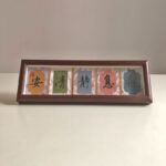 Framed Chinese mindfulness calligraphy desk art with protective glass and silk brocade matting.