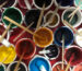 Top view of vibrant natural mineral pigment bowls and brushes used in traditional Thangka painting.