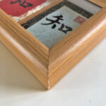 Macro detail of smooth natural wood frame corner showcasing Zhi He Xing 3-panel calligraphy