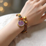 Purple Vajrasattva Buddha Eye charm bracelet on model wrist with handcrafted braided cord.