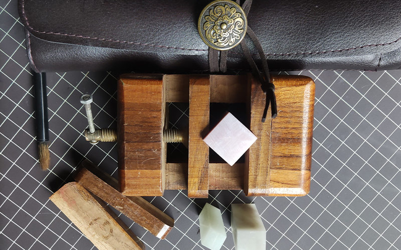 Traditional Chinese seal carving tools and stone stamp block on artist workbench