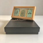3-panel Song Brocade calligraphy wooden frame displayed on top of elegant black luxury gift box