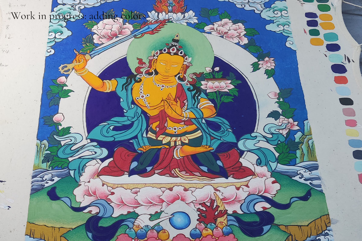 Work in progress showing the vibrant coloring phase of a handmade Thangka.