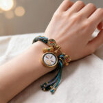 Handmade white Tara Buddha Eye pendant charm bracelet worn on wrist with woven cord detail.