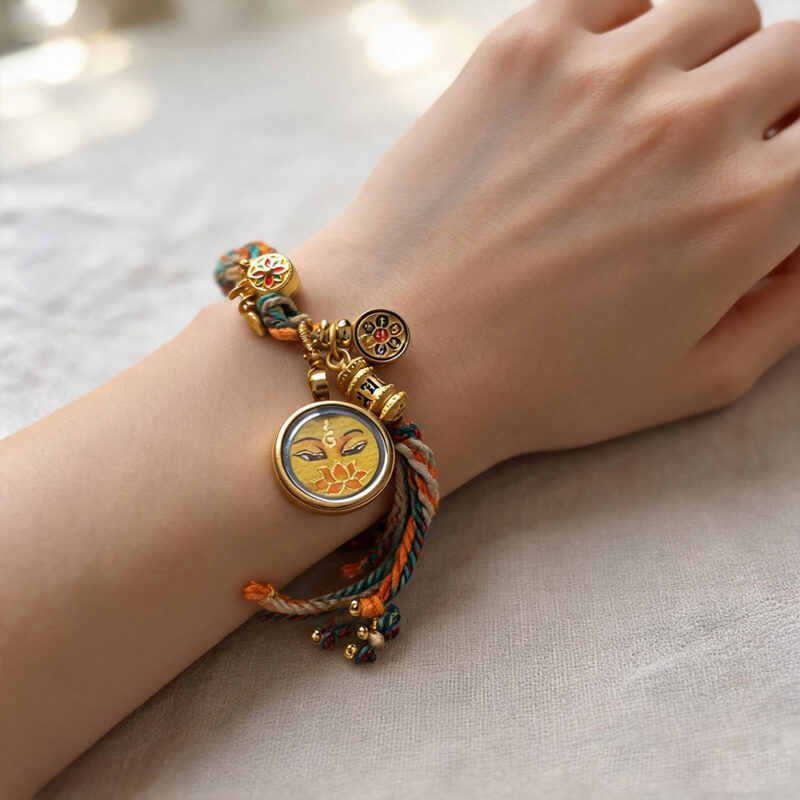 Yellow Manjushri Buddha Eye charm bracelet on model wrist with warm yellow accents.