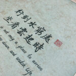 Macro detail of Xingzhuo Chinese calligraphy brush strokes and red seal stamp on fine art textured paper
